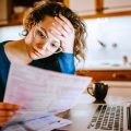 Woman going through bills, looking worried